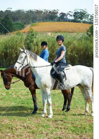 Women friends, horse riding and smile in portrait with helmet, ranger team or equestrian exercise. Girl outdoor together, jockey or happy on adventure, training or learning for contest in countryside Women friends, horse riding and smile in portrait with helmet, ranger team or equestrian exercise. Girl outdoor together, jockey or happy on adventure, training or learning for contest in countryside 138756017