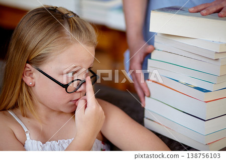 Thinking, concern and a child with books at a library for education, knowledge and learning. Looking, worry and a girl, kid and librarian with textbooks for studying, hobby or homework at school 138756103