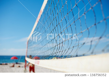 Volleyball, net and beach with blue sky outdoor for game, competition or match. Ocean, sports netting closeup or sand field for training, exercise and workout, fitness or sea for recreation in summer Volleyball, net and beach with blue sky outdoor for game, competition or match. Ocean, sports netting closeup or sand field for training, exercise and workout, fitness or sea for recreation in summer 138756352