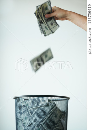 Bin, money or bills with finance, inflation or debt with bankruptcy, trash or global recession. Waste bucket, cash or economy issues with fraud, corruption or value decline on a studio background Bin, money or bills with finance, inflation or debt with bankruptcy, trash or global recession. Waste bucket, cash or economy issues with fraud, corruption or value decline on a studio background 138756419