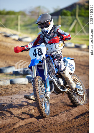 Person, motorcycle and dirt race track adventure as .professional in action, danger or fearless risk. Bike rider, off road course and fast speed competition rally, extreme sport gear on sand path 138756553