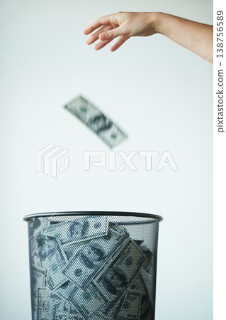 Dustbin, money or bills with finance, inflation or debt with bankruptcy, trash or global recession. Waste bucket, cash or economy issues with fraud, corruption or value decline on a studio background 138756589