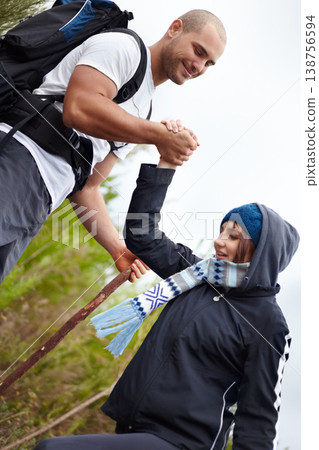 Helping hand, man and woman on hiking adventure in mountain with nature walk, wellness and support. Travel, trekking and happy couple in countryside holding hands on natural outdoor journey together. 138756594