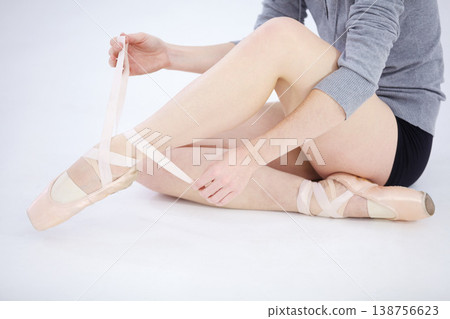 Ballet dancer, pointe shoes and closeup tie for elegance competition training, performance practice or cardio. Female person, legs ribbon and artistic expression, balance workout on white background Ballet dancer, pointe shoes and closeup tie for elegance competition training, performance practice or cardio. Female person, legs ribbon and artistic expression, balance workout on white background 138756623