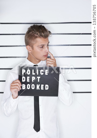 Crime, mugshot and man on a white background for suspect for criminal, illegal and fraud activity. Police station, height chart and person thinking with signboard for arrested, wanted and convict Crime, mugshot and man on a white background for suspect for criminal, illegal and fraud activity. Police station, height chart and person thinking with signboard for arrested, wanted and convict 138756705