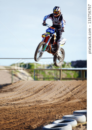 Person, motorcycle or bike jump on race track as professional in action competition, fearless or dust path. Rider, off road transportation for fast speed adventure or rally, extreme sport or gear Person, motorcycle or bike jump on race track as professional in action competition, fearless or dust path. Rider, off road transportation for fast speed adventure or rally, extreme sport or gear 138756767