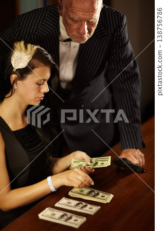 People, count and money with dollar for mafia in office while mob boss, stand and gun for watching. Young woman, retro and fashion with cash on table, desk and checking of fraud in criminal activity People, count and money with dollar for mafia in office while mob boss, stand and gun for watching. Young woman, retro and fashion with cash on table, desk and checking of fraud in criminal activity 138756786