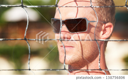 Face, sunglasses and volleyball at the beach with a man by a net in summer for sports or recreation. Fitness, thinking and shades with an athlete outdoor for a game or match of competition closeup Face, sunglasses and volleyball at the beach with a man by a net in summer for sports or recreation. Fitness, thinking and shades with an athlete outdoor for a game or match of competition closeup 138756806