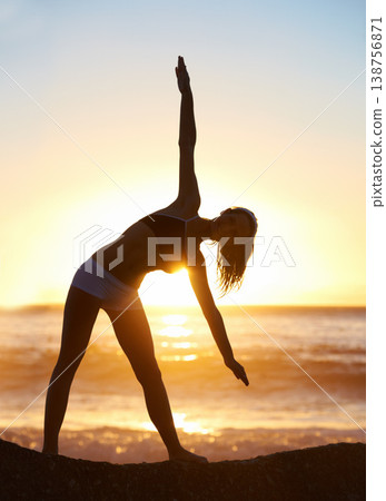 Woman, silhouette and yoga for balance on beach with trikonasana pose for stretching, zen or meditation. Person, shadow and mindset for peace, calm or relaxing at sunset with movement for muscles Woman, silhouette and yoga for balance on beach with trikonasana pose for stretching, zen or meditation. Person, shadow and mindset for peace, calm or relaxing at sunset with movement for muscles 138756871
