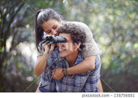 Man, woman and piggyback in forest with binocular for travel, adventure or sightseeing in nature with happiness. Couple, people and tourist hiking outdoor in woods for experience, holiday or vacation Man, woman and piggyback in forest with binocular for travel, adventure or sightseeing in nature with happiness. Couple, people and tourist hiking outdoor in woods for experience, holiday or vacation 138756881