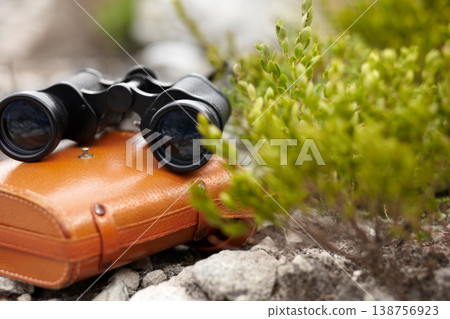 Binoculars, explore and outdoors in nature for travel, discover and equipment for closeup or zoom. Field glasses, vision and telescope for observation, view and finding or search on ground to scout 138756923