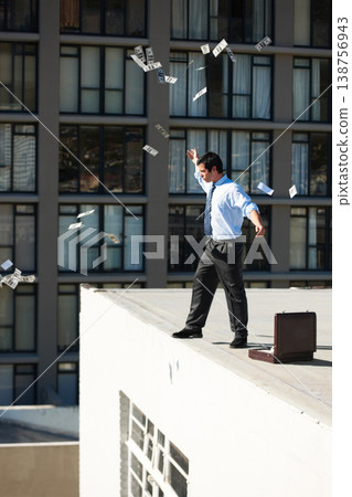 Business, financial freedom and money rain with a man in the city, throwing cash during a summer day. Finance, success or raining dollars with an employee on the roof of a building in an urban town 138756943