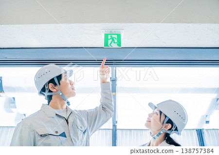 身穿工作服的男女正在檢查消防安全設備。 138757384