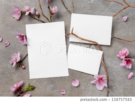 Blank wedding cards suite mockup with pink cherry blossoms and twigs on grey stone. Spring stationery 138757583