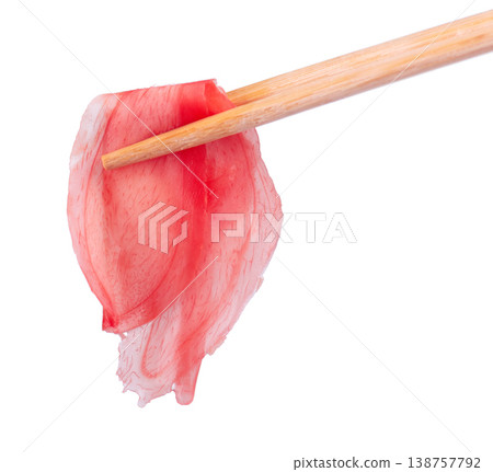 Pickled ginger slices held by wooden chopsticks isolated on white background. Heap of marinated ginger. Clipping path. 138757792