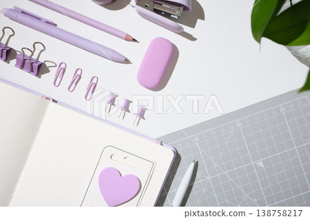 Purple stationery, open dotted notebook, and office supplies on white desk. Copyspace Purple stationery, open dotted notebook, and office supplies on white desk. Copyspace 138758217