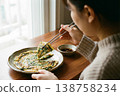 Person Eating Korean Chive Pancake with Chopsticks Close View 138758234