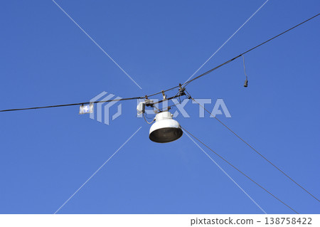 Old street lamp hanging on wires Old street lamp hanging on wires 138758422