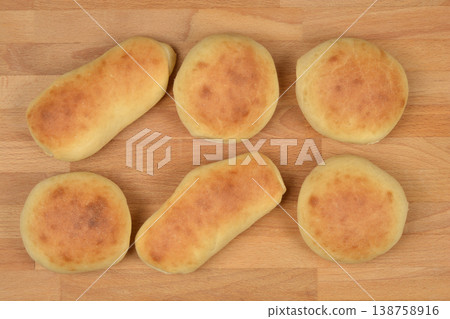 Homemade golden brown buns and rolls on wooden surface 138758916