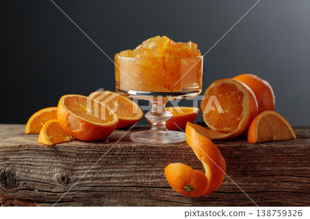 Orange jelly in a glass dessert bowl on an old wooden table. Orange jelly in a glass dessert bowl on an old wooden table. 138759326