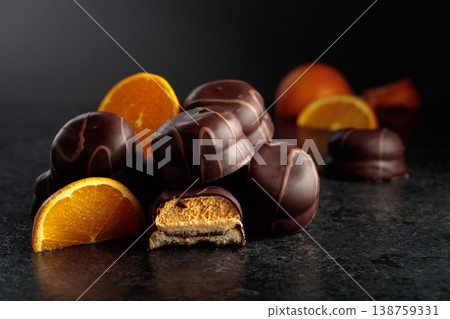Chocolate dessert with slices of fresh oranges on a black background. Chocolate dessert with slices of fresh oranges on a black background. 138759331