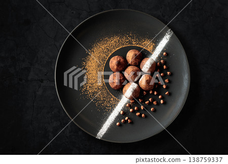 Chocolate truffles on a black plate. Chocolate truffles on a black plate. 138759337