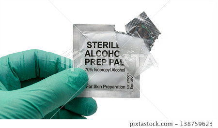 Gloved hand in medical glove holding sterile alcohol prep pad, representing skin antisepsis, injection preparation, and clinical hygiene Gloved hand in medical glove holding sterile alcohol prep pad, representing skin antisepsis, injection preparation, and clinical hygiene 138759623