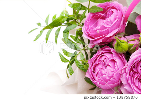 Close-up bouquet of pink peony roses with green leaves in elegant packaging. Botanical background with copy space. A floral gift for a special occasion. Close-up bouquet of pink peony roses with green leaves in elegant packaging. Botanical background with copy space. A floral gift for a special occasion. 138759876