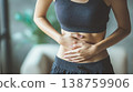Woman with stomach discomfort faces daily challenges in a busy environment during the day 138759906