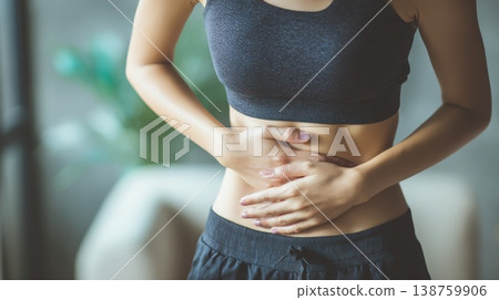 Woman with stomach discomfort faces daily challenges in a busy environment during the day Woman with stomach discomfort faces daily challenges in a busy environment during the day 138759906