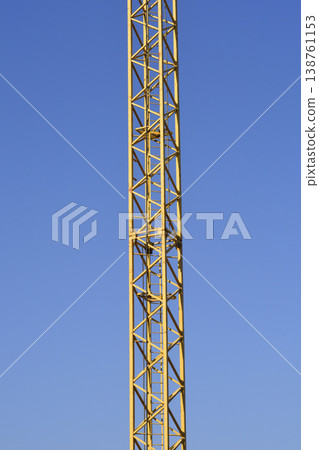 Yellow Construction Crane Tower Against Blue Sky Yellow Construction Crane Tower Against Blue Sky 138761153