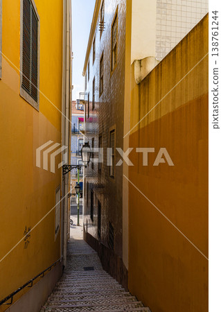 Narrow Lisbon Alley with Stairs and Yellow Walls Portugal 138761244