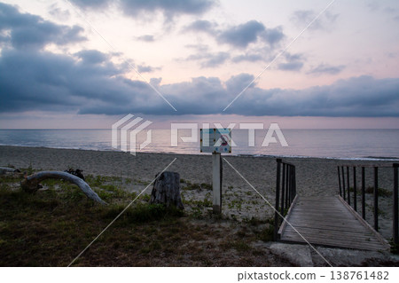 在地中海的法國科西嘉島上，日出前從海岸線可以看到橘色的天空，天空被雲層和大海環繞。 138761482