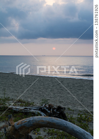 在地中海的法國科西嘉島上，從海岸線上可以看到日出，橙色的天空被雲層和大海環繞。 138761926