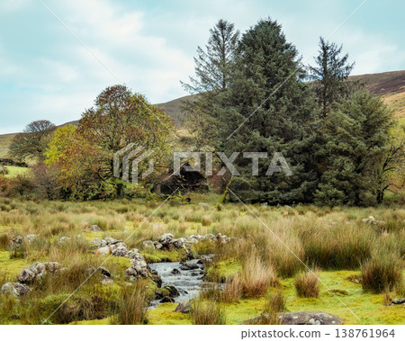 Creek flows past a derelict stone building in a wild moorland landscape with trees and distant hills. Creek flows past a derelict stone building in a wild moorland landscape with trees and distant hills. 138761964