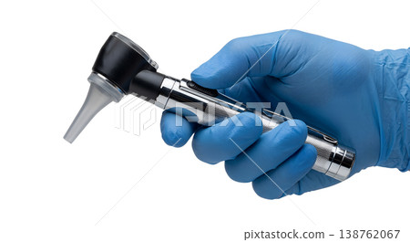 Gloved hand wearing a blue nitrile glove holding a medical otoscope with a speculum attachment, representing ear examination and clinical diagnostics Gloved hand wearing a blue nitrile glove holding a medical otoscope with a speculum attachment, representing ear examination and clinical diagnostics 138762067