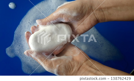 Hands holding soap with bubbles in a blue setting during cleaning process Hands holding soap with bubbles in a blue setting during cleaning process 138762429
