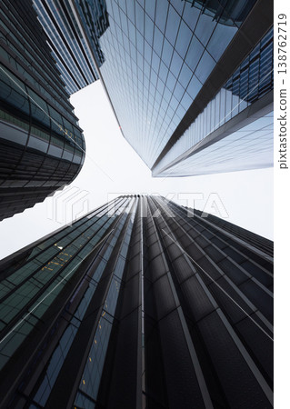 Low angle view of modern glass skyscrapers reaching into the sky Low angle view of modern glass skyscrapers reaching into the sky 138762719