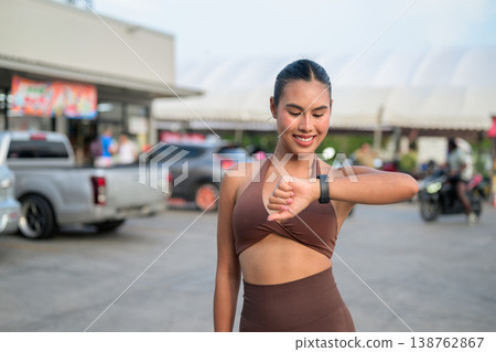 Thai Fitness Influencer Checking Smartwatch at Tropical Outdoor Market Modern Digital Lifestyle Concept Thai Fitness Influencer Checking Smartwatch at Tropical Outdoor Market Modern Digital Lifestyle Concept 138762867