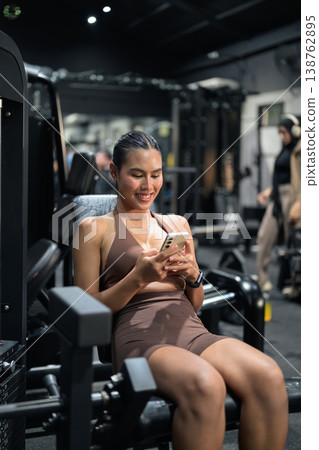 Thai Fitness Influencer Checking App on Leg Extension Machine Gym Training Done Concept Thai Fitness Influencer Checking App on Leg Extension Machine Gym Training Done Concept 138762895