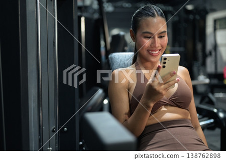 Thai Fitness Influencer Tracking Progress on Smartphone at Gym Gym Training Done Concept Thai Fitness Influencer Tracking Progress on Smartphone at Gym Gym Training Done Concept 138762898