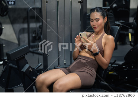 Thai Fitness Influencer Tracking Progress on Smartphone at Gym Gym Training Done Concept Thai Fitness Influencer Tracking Progress on Smartphone at Gym Gym Training Done Concept 138762900