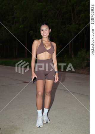 Full Length Portrait of Smiling Thai Fitness Influencer at Night Modern Wellness Concept Full Length Portrait of Smiling Thai Fitness Influencer at Night Modern Wellness Concept 138762928
