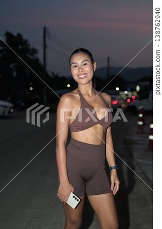 Smiling Thai Fitness Influencer on Night Road After Jogging Healthy Lifestyle Concept 138762940