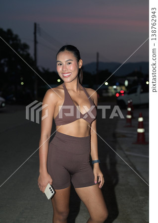 Smiling Thai Fitness Influencer on Twilight Road After Running Healthy Lifestyle Concept 138762943