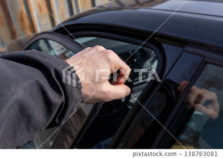 A man opens a sleek car door, showcasing modern design and urban life, set against the backdrop of a lively city street A man opens a sleek car door, showcasing modern design and urban life, set against the backdrop of a lively city street 138763081