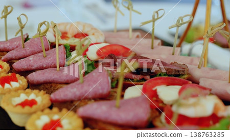 Elegant catering platter displaying vibrant canapes featuring cured meats, cheeses, vegetables, and seafood, highlighting gourmet culinary presentation for sophisticated gatherings Elegant catering platter displaying vibrant canapes featuring cured meats, cheeses, vegetables, and seafood, highlighting gourmet culinary presentation for sophisticated gatherings 138763285