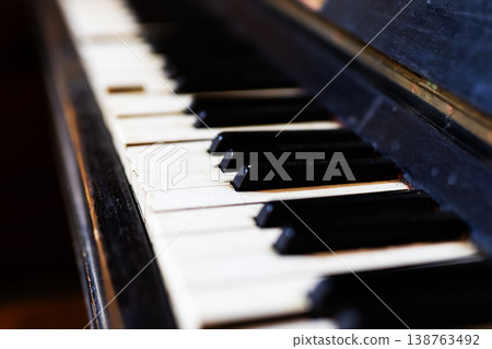 Detailed image emphasizing weathered condition of piano keys illuminated by gentle warm light Detailed image emphasizing weathered condition of piano keys illuminated by gentle warm light 138763492