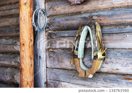 Old horse harness. Faded horse collar displayed on aged barn wall with weathered wood 138763560
