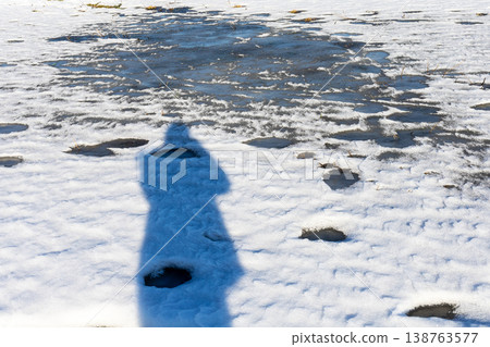 Solitary snow photographer. Shadowy figure photographs snowfield in peaceful solitude Solitary snow photographer. Shadowy figure photographs snowfield in peaceful solitude 138763577